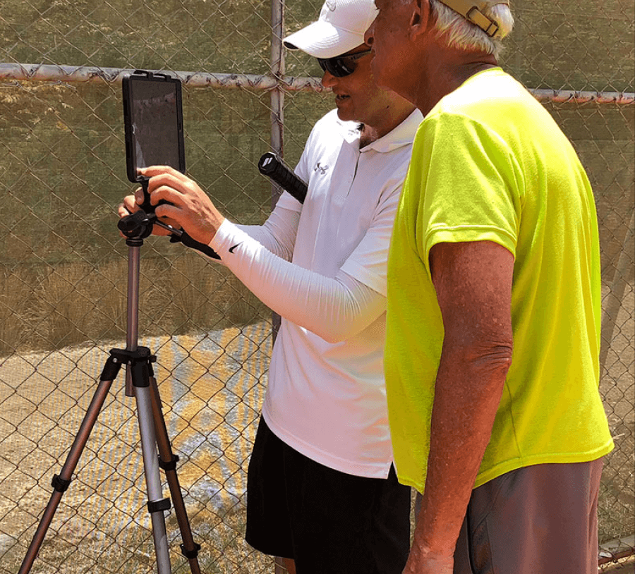 A coach reviewing a player stroke on camera during an OTI session
